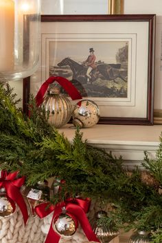 christmas decorations on a mantle with a horse in the background