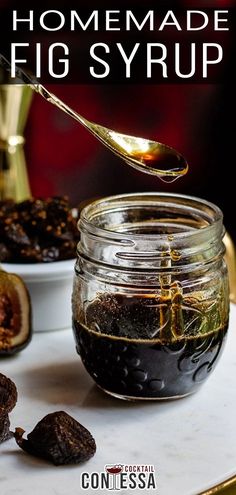 a jar filled with figs sitting on top of a table next to other food