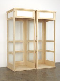 an empty room with two wooden shelves on the floor