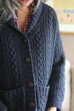 a woman with grey hair wearing a blue cardigan