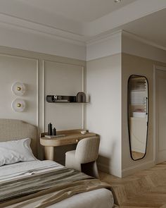 a bedroom with a bed, desk and mirror on the wall next to each other