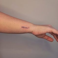 a person's arm with a small tattoo on the left side of their arm