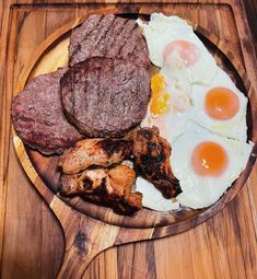 a wooden plate topped with meat and eggs