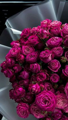 a bouquet of purple roses in front of a computer keyboard