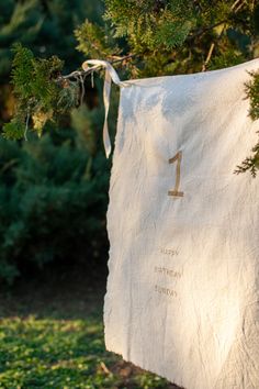 a white towel hanging from a tree with the number one on it