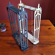 two decorative metal items sitting on top of a wooden table next to each other,