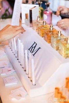 a table topped with lots of different types of perfumes