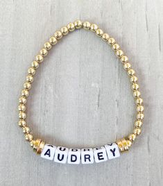 Gold Name Bracelet ✨✨ Made with 18k gold filled beads so your bracelet won't tarnish ✨✨ Get your name, your last name, your kids names or whatever you want. This little cute bracelet goes with any stack and looks good by itself ✨ Made with 18k gold filled round beads and 4mm square letters **Also available in Silver and Rose Gold** Please put name or word in Personalization Section* CARING TIPS FOR YOUR JEWELRY ⭐️Treat and store with care. ⭐️ For longevity, avoid exposing your jewelry to water. ⭐️ Avoid having direct contact with lotions, perfumes, sanitizers as these chemicals may cause discoloration of your jewelry. Gold Stretch Bangle With Letter Beads, Gold Stretch Bangle Bracelet With Letter Beads, Elegant Gold Friendship Bracelets With Letter Beads, Adjustable Gold Name Bracelet With Letter Beads, Gold Letter Beads Charm Bracelet For Friendship, Gold Charm Bracelet With Letter Beads For Friendship, Adjustable Gold Friendship Bracelets With Letter Beads, Gold Custom Name Charm Bracelet For Friendship, Gold Charm Bracelet With Custom Name For Friendship