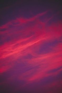 the sky is pink and purple with some clouds