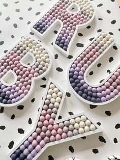 the letters are made out of beads and decorated with black dots on a white tablecloth