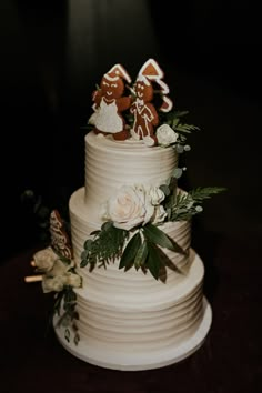 a wedding cake decorated with gingerbread cookies and flowers