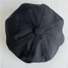 a black hat sitting on top of a white floor