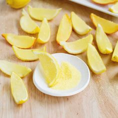 sliced lemons on a wooden table next to a white plate