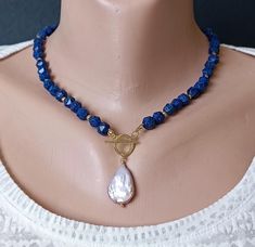 Handmade necklace from navy blue natural lapis lazuli beads with pendant pearl Baroque. Necklace will be a good gift, anniversary, or birthday. gift for wife, gift for girlfriend, gift for sister, gift for mom, gift for daughter, gift for her. Materials: lapis lazuli, Baroque pearl size 25x15x5 mm, 14K details.  Necklace length +/- 17.7" - 45 cm). Recommendations for care: Do not wet, do not drop, avoid contact with perfumes, detergents. Wear with pleasure! IMPORTANT!  All items are shipped with Blue Pearl Necklace With Natural Stones For Gift, Blue Pearl Necklace With Natural Stones As A Gift, Blue Beaded Necklace With Pearl Drop For Gift, Blue Lapis Lazuli Pearl Necklace Gift, Blue Pearl Necklace With Pearl Charm As Gift, Blue Pendant Pearl Necklace As Gift, Blue Pendant Pearl Necklace For Gift, Lapis Lazuli Pendant Beaded Necklace As Gift, Lapis Lazuli Pendant Beaded Necklace For Gifts