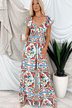 100% POLYESTER Model Wearing Size Small Color: Multi Satin Material Floral/Abstract Print Elastic Shoulders With Flutter Sleeves V-Neckline Smocked Waist & Upper Back Back Cut-Out Wide Leg Jumpsuit Has Good Stretch 30“ Inseam For Model Size Specs Please Check Size Charts Launched: 5/28/24 Vacation Jumpsuits And Rompers With V-neck And Elastic Waistband, Bohemian Printed V-neck Jumpsuits And Rompers, Casual Floral Print V-neck Jumpsuits And Rompers, Summer Printed V-neck Jumpsuit, Patterned Printed Jumpsuits And Rompers For Spring, White Printed V-neck Jumpsuits And Rompers, Spring Casual Multicolor Print Jumpsuits And Rompers, Summer Multicolor Jumpsuits And Rompers With Ruffles, Summer Multicolor Jumpsuit With Ruffles