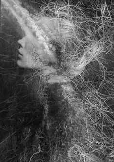 a black and white photo of a woman's face with hair blowing in the wind