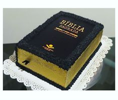 a cake that is shaped like a bible on top of a table with doily