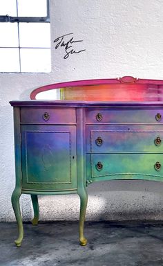 a multicolored desk with drawers and writing on it