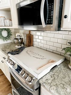 a stove top oven sitting inside of a kitchen next to a wall mounted microwave above it