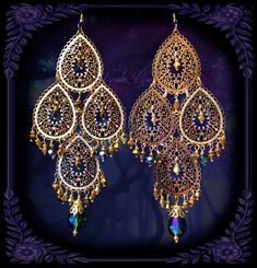 "This pair of Handmade Chandelier Earrings is made with 3 tiers of lacy gold plated filigrees. Metallic Gold and Montana Blue crystal beads dangle from the design. Pierced with french wires (as shown), clip-ons, leverbacks or posts, just select from the pull-down menu. -5 1/4\" Long x 2\" Wide -0.4 oz. ea. Bead Colors Available in the Pull-Down Menu: The Metallic Gold is pictured Metal Finishes Available: -Gold(as pictured) -Silver *Comes Ready To Gift in Decorative Packaging *Each Pair is Made Bohemian Chandelier Earrings With Filigree For Parties, Blue Crystal Beads, Handmade Chandelier, Weight Scale, Teardrop Dangle Earrings, Pretty Jewelry, French Wire, Gold Filigree, Gems Jewelry