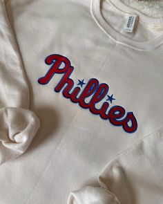 This custom Phillies embroidered sweatshirt is plush and comfy. It's ideal for relaxing, running errands, watching/ attending a Phillies game, or walking your fur baby.  *Sweatshirt/ Hoodie Brand: Jereezs MID- WEIGHT *Sizes available: Adult Small - Adult 3X                                50% Cotton/ 50% Polyester  *Washing Instructions  Turn the garment inside out. Machine wash cold with similar colors on a gentle cycle. Tumble dry low and remove promptly. Fan Merchandise Crew Neck Sweatshirt, Diy Phillies Shirt, Los Angles Sweat Shirt, Phillies Crewneck, Phillies World Series 2022 Shirts, Phillies Game, Hoodie Brands, Football Gifts, Embroidered Sweatshirts