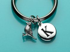 a close up of a key chain with a bird on it's side and an arrow in the middle