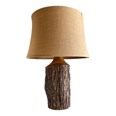 a table lamp with a wooden base and a beige shade on the top, against a white background