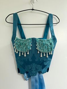 Made-to-order & historically inspired bustier. Corseted bodice in teal blue brocade, boned with a mixture of polyester and steel boning.  You have the options of 2 shapes for this piece, the Scalloped Hem (photo 1) or Curved Hem (photo 2) Soft aqua cups in silk velvet, ruched with elastic for a stretchy and comfortable fit in the balconette style. Embellished by hand with a combination of freshwater and glass pearl beading to create organic droplets around the bust.  Lace up back fastened with s Ballroom Dance Outfits, Velvet Corset, Blue Corset, Corset Bustier, Corset Lingerie, Blue Lagoon, Bustier Top, Bustiers, Silk Velvet