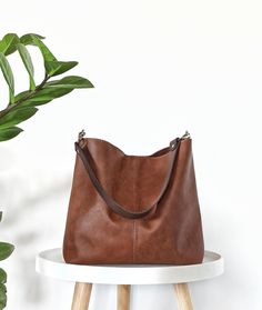 Minimalist and classic hobo bag in cognac brown *The exterior of the bag is made of high quality artificial leather in beautiful rich cognac brown color.  Very practical for carrying on the shoulder, and as a cross body (if crossbody strap is added).  The bag is light and well structured and the wider strap guarantees comfort for the shoulder.  *The interior is made of cotton fabric in medium grey.  It has 2 slip inner pockets which are perfect for your phone and smaller items.  *Magnetic snap c Brown Rectangular Hobo Bag For Everyday Use, Versatile Brown Hobo Bag With Large Capacity, Large Capacity Cognac Hobo Shoulder Bag, Cognac Large Capacity Hobo Shoulder Bag, Light Brown Large Capacity Crossbody Hobo Bag, Brown Hobo Shoulder Bag For Errands, Brown Double Handle Hobo Bag For Everyday, Everyday Brown Hobo Bag With Double Handle, Everyday Large Capacity Brown Hobo Bag