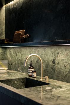 a bathroom sink sitting under a mirror next to a faucet and soap dispenser