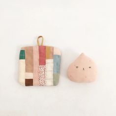 a small patchwork purse next to a stone shaped like a cat