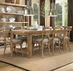 a dining room table with chairs and plates on it in front of a bookcase