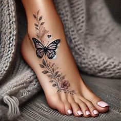 a woman's foot with a butterfly and flowers tattoo on the bottom of it