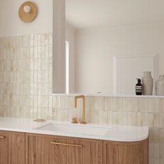 a bathroom sink sitting under a mirror next to a counter top with soap dispenser