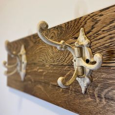 two metal hooks are attached to a wood panel