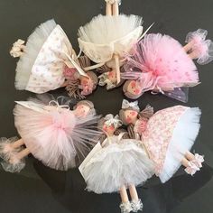 a group of dolls sitting on top of a table next to each other in tutu skirts