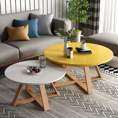 two coffee tables sitting next to each other on top of a rug in front of a couch