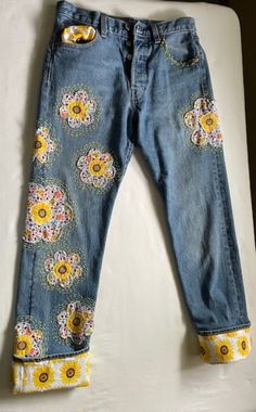 a pair of blue jeans with yellow flowers on them