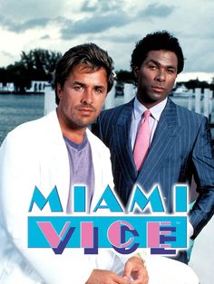 two men standing next to each other in front of a poster for the movie miami vice