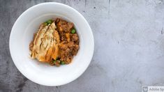 a white bowl filled with food on top of a table