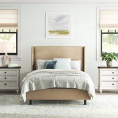 a bedroom with white walls and beige furniture