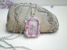 "Up for sale is this beautiful pink camphor glass sterling silver pendant and link necklace. The pendant is signed H with two triangles one on each side of the H and I believe this is from the 1920's.  The link chain is signed D&C for Daggett & Clap Co.,  from era 1896 to 1915 and it features a tube catch clasp from that time.   *Metal Purity: Sterling Silver (tested) *Gemstone:Camphor Glass *Pendant Width:24.8mm tall ∣ 17.2mm wide *Necklace Length: 17\"  Long   *Chain Width:2mm wide *Weight: Pink Vintage Charm Pendant Jewelry, Antique Hallmarked Pink Jewelry, Antique Pink Hallmarked Jewelry, Pink Antique Hallmarked Jewelry, Elegant Pink Jewelry With Engraving, Elegant Pink Locket Jewelry, Elegant Engraved Pink Jewelry, Elegant Pink Engraved Jewelry, Antique Pink Necklaces For Wedding