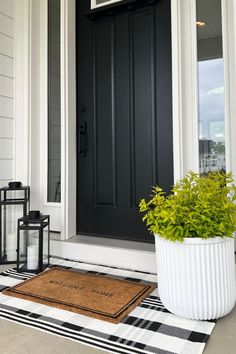 a black front door with a potted plant next to it