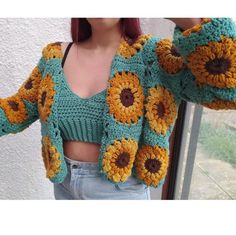 a woman with red hair wearing a sunflower sweater