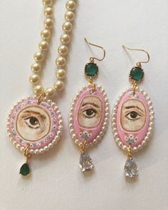 three necklaces with pearls, beads and an eye in the shape of a woman's face