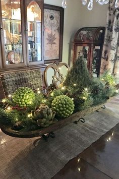 a dining room table decorated for christmas with lights and greenery on the centerpiece