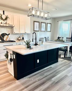 a kitchen with white cabinets and black island