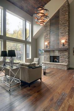 a living room filled with furniture and a fire place in front of a large window