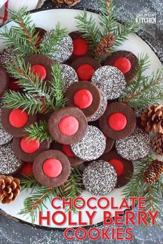 chocolate holly berry cookies on a plate with pine cones