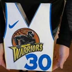 a person holding up a basketball jersey with the number 30 on it's chest